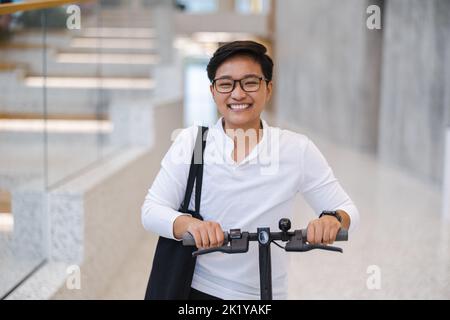 Junger Mann mit einem Elektroroller Stockfoto