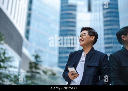 Lächelnde junge Unternehmer mit Handy in der Stadt Stockfoto