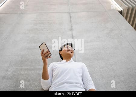 Lächelnder junger Mann mit Handy Stockfoto