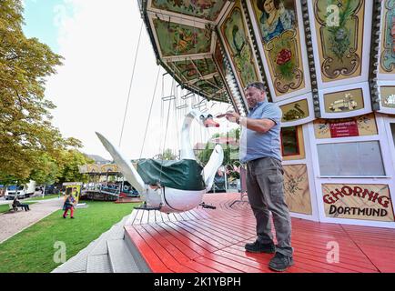 Stuttgart, Deutschland. 21. September 2022. Günther Hornig aus Dortmund repariert Lackschäden an seinem historischen Karussell Schwanenflieger. Am 24. September startet das Historische Volksfest auf dem Stuttgarter Schlossplatz. Quelle: Bernd Weißbrod/dpa/Alamy Live News Stockfoto