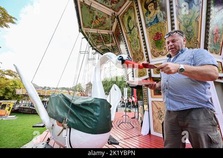 Stuttgart, Deutschland. 21. September 2022. Günther Hornig aus Dortmund repariert Lackschäden an seinem historischen Karussell Schwanenflieger. Am 24. September startet das Historische Volksfest auf dem Stuttgarter Schlossplatz. Quelle: Bernd Weißbrod/dpa/Alamy Live News Stockfoto