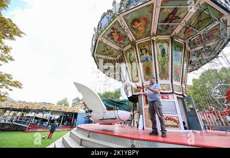 Stuttgart, Deutschland. 21. September 2022. Günther Hornig aus Dortmund repariert Lackschäden an seinem historischen Karussell Schwanenflieger. Am 24. September startet das Historische Volksfest auf dem Stuttgarter Schlossplatz. Quelle: Bernd Weißbrod/dpa/Alamy Live News Stockfoto