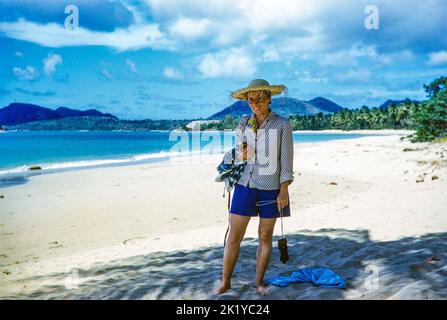 Weibliche Touristin mit Strohhut am sandigen Vigie-Strand, St. Lucia, Windward Islands, West Indies, 1962 Stockfoto