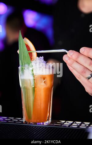 Zombie Barkeeper macht einen Cocktail auf Basis von Rum, Grapefruit und Zimtsirup Stockfoto