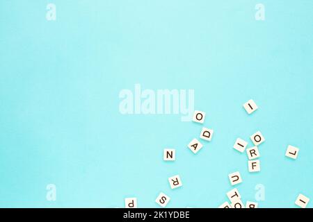 Zufällige Buchstaben auf blauem Hintergrund. Verstreutes englisches Alphabet. Speicherplatz kopieren. Abstrakter minimalistischer Hintergrund Stockfoto