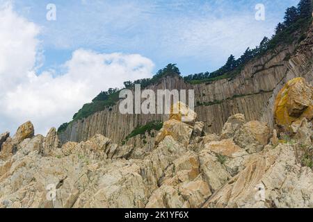 Küste der Insel Kunashir am Kap Stolbchaty mit basaltsäulen Felsen Stockfoto