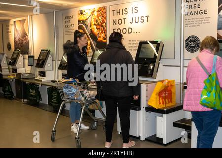 Lady Shopper, die für ihre Waren in einem Selbstbedienungsmarkt und Spencers Supermarkt in Norwich Norfolk bezahlen Stockfoto