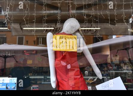 (220921) -- ROM, 21. September 2022 (Xinhua) -- ein aufblasbarer Dummy und ein gelbes Schild mit der Aufschrift "die Rechnung ist angekommen" sind in der Bar Big Mamy in Rom, Italien, am 17. September 2022 zu sehen. In der Bar Big Mamy in Rom trug ein aufblasbarer Dummy, der am Fenster hing, ein gelbes Schild mit der Aufschrift „die Rechnung ist angekommen“. Laura Ramoni, Inhaberin der Bar, sagte Xinhua, dass die Stromrechnung der Bar in diesem Juni und Juli bei etwa 2.600 Euro lag, was sich im Vergleich zum Vorjahreszeitraum fast verdreifachte. „Wir können die Rechnung nicht bezahlen“, sagte sie. „Ich muss zwei Leute feuern, die hier gearbeitet haben, und ich habe den Kof angehoben Stockfoto