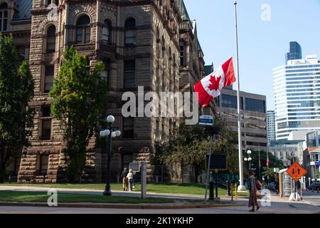 Eine kanadische Flagge mit Halbmast oder halbem Personal im Zentrum von Toronto an der Old City Hall auf der Queen Street; gesehen nach dem Tod von HM Queen Elizabeth II. Stockfoto