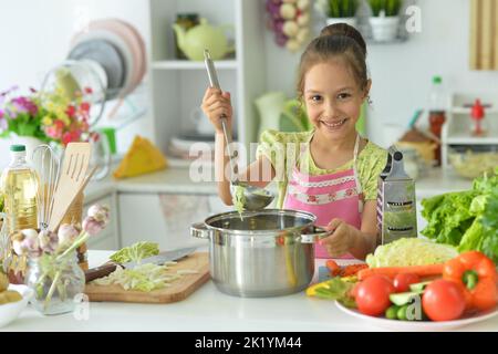 Schönes Mädchen, das einen Salat in der Küche zubereitet Stockfoto