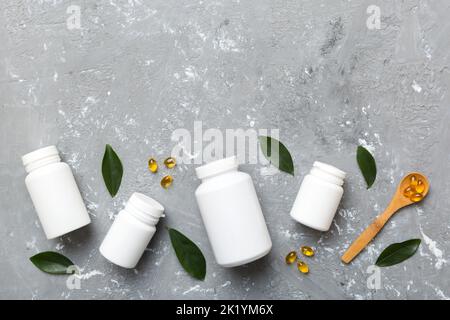 Omega-3 Kapseln liegen in einer weißen Flasche auf einem Tisch mit grünem Blatthintergrund. Fischöltabletten. Biologisch aktive Zusatzstoffe. omega 6, Omega 9, Vitam Stockfoto