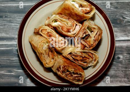 Syrisches Rezept Küche Hintergrund, eine Platte aus Stücken von Huhn Shawerma oder Shawarma Tortilla Wrap mit Zwiebeln, Tomaten, Salat und Knoblauchsauce in Syri Stockfoto