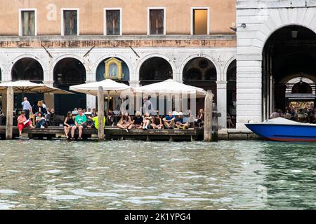 Touristen, die eine Pause in der Nähe eines Wasserkanals in Venedig, Italien Stockfoto