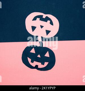 Blauer und pinker Hintergrund mit blauem und pinkem Papierkürbis, kreatives Kunstdesign, halloween Minimalkonzept, flaches Lay Stockfoto