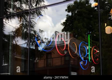 Ein farbenfrohes, beleuchtetes Google-Logo in einem Bürogebäude in Kitchener, Kanada; an einem sonnigen Tag durch ein Fenster zu sehen. Stockfoto