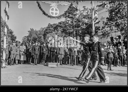 Besetzte Norwegen Propagandademonstration des Zweiten Weltkriegs von Nasjonal Samling (NS), Vidkun Quislings norwegischer Nazi-Partei während des Zweiten Weltkriegs, Sarpsborg Deutsch besetzte Norwegen vom 20. Bis 21. Juni 1942, mit politischen Reden, paramilitärischen Truppen der Uniformierten Partei, auf Parade durch die Stadt, Norwegen 2. Weltkrieg Nasjonal Samling (Norwegisch NS; lit. Nationale Versammlung) war eine rechtsextreme norwegische Partei, die von 1933 bis 1945 aktiv war. Es war die einzige juristische Partei Norwegens von 1942 bis 1945. Sie wurde von dem ehemaligen Verteidigungsminister Vidkun Quisling gegründet, der hier auf dem Podium zu sehen war, und einer Gruppe von Unterstützern Stockfoto