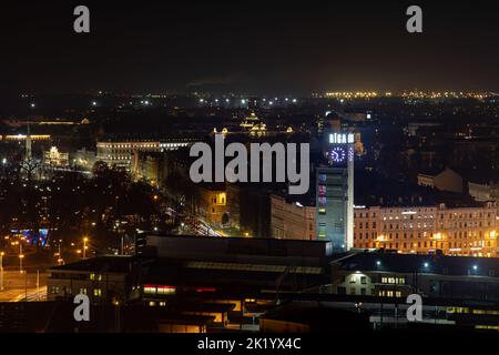 Bei Nacht haben Sie einen schönen Blick auf Riga, im Zentrum befindet sich die Uhr des Hauptbahnhofs Stockfoto