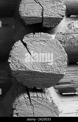 Eckdetail eines Vintage Holzblockkabinenrahmens in schwarz-weißem Schwarz-Weiß-Schwarz. Stockfoto