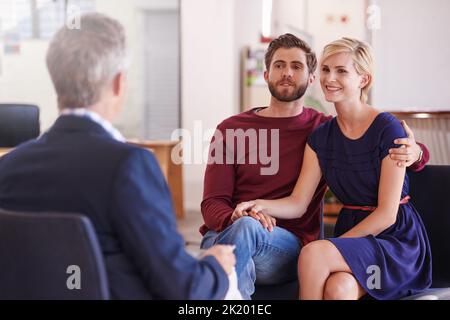 Er hat immer gute finanzielle Tipps für sie. Junges Paar diskutiert Investitionspläne mit einem Finanzberater. Stockfoto