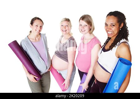 Bereit für den Yoga-Kurs. Schwangere stehen zusammen und halten ihre Yogamatten, während sie isoliert auf Weiß stehen. Stockfoto