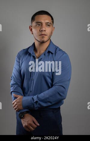 Trägt ein blaues Hemd ein junger Mann aus latein mit kurzen Haaren, Geschäftsmann im Studio, Lifestyle und Mode im Studio Stockfoto
