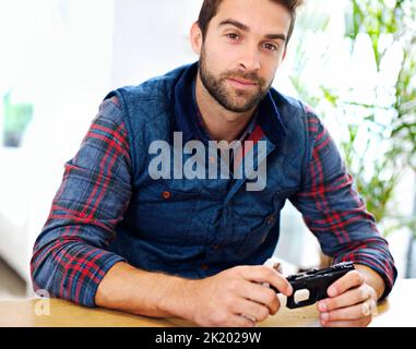 Regelmäßige Wartung ist für jeden Waffenbesitzer unerlässlich. Ein junger Mann, der seine Waffe putzt. Stockfoto