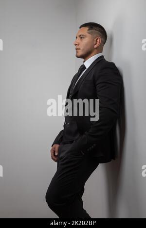 Ein junger latein mit kurzen Haaren, Geschäftsreisenden und Lifestyle, elegant in einem Anzug mit Hemd und Krawatte, Stockfoto