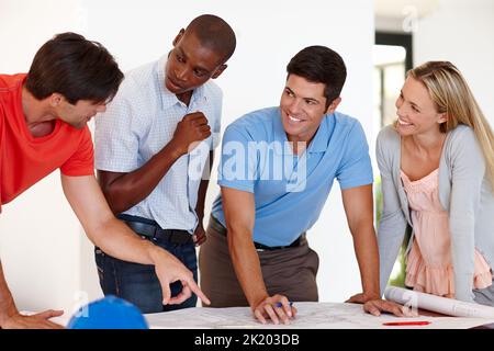 Was denkst du. Ein Team von Architekten diskutiert Baupläne im Büro. Stockfoto