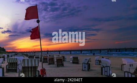 Rote Flagge bei Sonnenuntergang in Bansin Stockfoto