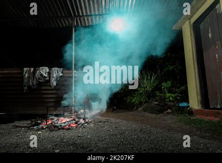 Ländliche Menschen kochen große Mahlzeiten mit Holz und einfachen Töpferwaren Stockfoto