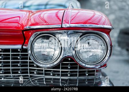 Many classic red vintage old american cars parked in row at garage, exhibition of fest. Close-up detail view beautiful retro oldtimer vehicle hood Stockfoto
