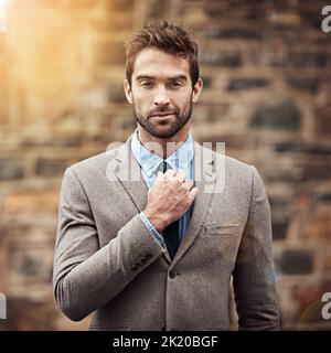 Ein hübscher und stilvoller junger Geschäftsmann in einer urbanen Umgebung. Stockfoto