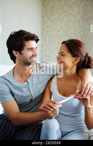 Begeistert von der Zukunft. Glückliches Paar beim Lesen eines Schwangerschaftstests. Stockfoto