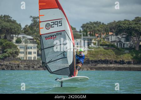 Ein Mann nimmt an einem nationalen Windsurf-Hydrofoil-Rennen beim Waterbourne Watersports Festival, Takapuna Beach, Auckland, Neuseeland, Teil. Stockfoto