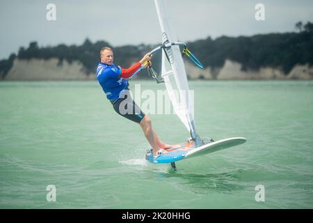 Ein Mann nimmt an einem nationalen Windsurf-Hydrofoil-Rennen beim Waterbourne Watersports Festival, Takapuna Beach, Auckland, Neuseeland, Teil. Stockfoto