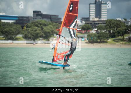 Ein Mann nimmt an einem nationalen Windsurf-Hydrofoil-Rennen beim Waterbourne Watersports Festival, Takapuna Beach, Auckland, Neuseeland, Teil. Stockfoto