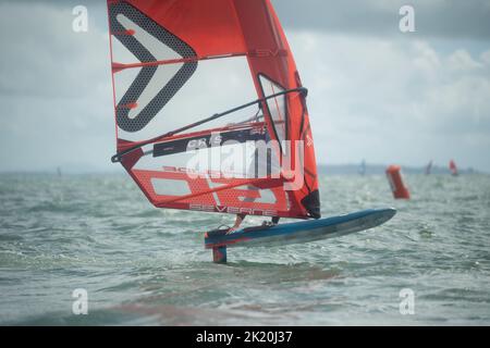 Ein Mann nimmt an einem nationalen Windsurf-Hydrofoil-Rennen beim Waterbourne Watersports Festival, Takapuna Beach, Auckland, Neuseeland, Teil. Stockfoto