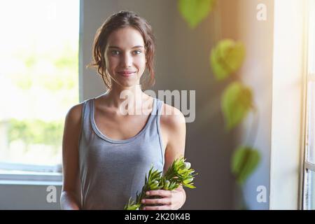 Sehen Sie, was die anderen nicht sehen. Eine junge Frau, die gerade ein Blumenarrangement anstellt. Stockfoto