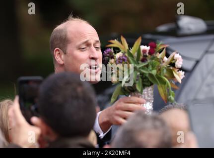 Prinz William nimmt einige Blumen an. Prinz William, der Prinz von Wales, und Catherine, die Prinzessin von Wales, sehen Sie sich die Blumengebete an, die am 15. September an den Norwich Gates, Sandringham, Norfolk, Großbritannien, zurückgelassen wurden, 2022. Das Land trauert noch offiziell um Königin Elisabeth II., die von König Karl III. Abgelöst wurde Königin Elizabeth II. Starb am 8. September 2022, als sie im Balmoral Castle in Schottland wohnte. Stockfoto