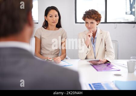 In Konferenz. Eine Gruppe von Geschäftsleuten, die an einem Konferenztisch sitzen und ein Meeting abhalten. Stockfoto