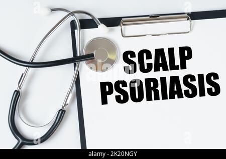 Medizinisches Konzept. Auf einer weißen Oberfläche, ein Stethoskop und eine Tablette mit einer Inschrift - Scalp Psoriasis Stockfoto