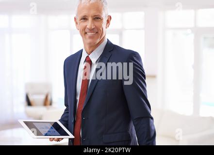Unterwegs arbeiten. Ein reifer Geschäftsmann mit einem Tablet. Stockfoto