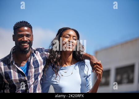 Glücklich zu sein geht nie aus dem Stil. Ein liebevolles Paar, das draußen läuft. Stockfoto