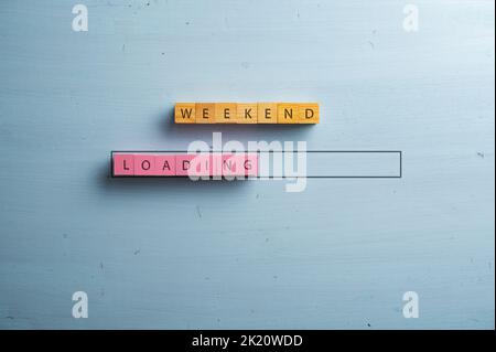 Weekend-Ladeschild auf rosa und braunen Holzblöcken in einer Ladebar geschrieben. Über blauem Holzhintergrund. Stockfoto