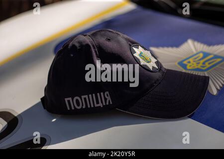 Hut des ukrainischen Polizisten mit Schild Polizei in ukrainischer Sprache und Logo der Polizeibehörde Stockfoto