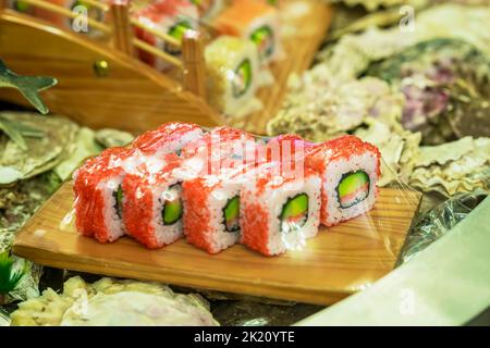 Sushi-Rollen auf Holzbrett. Essen zum Mitnehmen, Ernährung und Lieferung Konzept Stockfoto