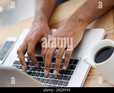 Hart bei der Arbeit. Beschnittene Ansicht eines Geschäftsmanns Hände, während er auf seinem Laptop eingibt. Stockfoto