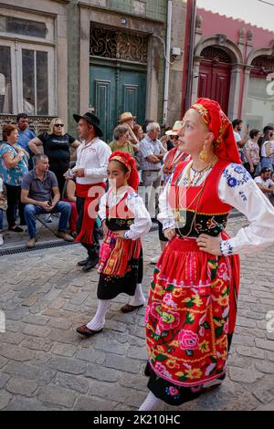 Ponte de Lima - 10. September 2022: Junge Menschen in den traditionellen Kostümen Nordportugals bei der Feiras Novas Festparade. Stockfoto