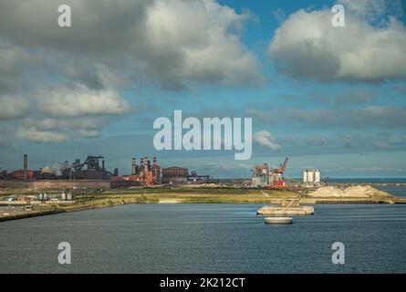 Europa, Frankreich, Dunkerque - 9. Juli 2022: Hafenlandschaft. Blick leicht nach Westen zum Kohlekraftwerk und zum Lagerdock unter blauer Wolkenlandschaft Stockfoto