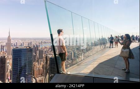 Eine Frau macht ein Smartphone-Foto von einem Mann auf dem Aussichtsterrasse Edge in Hudson Yards, Manhattan, NYC, USA Stockfoto